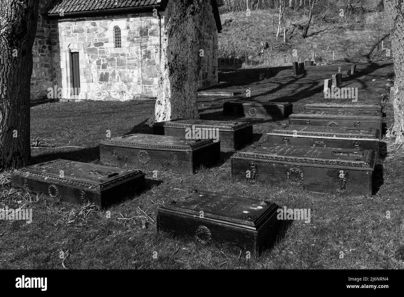 Gusseiserner Sarg als Grabmarker in Erinnerung an die Familie Ravn aus dem 19.. Jahrhundert auf dem Friedhof St. Jetmund`s aus dem 12.. Jahrhundert in Åheim, Vanylven, Norwegen Stockfoto